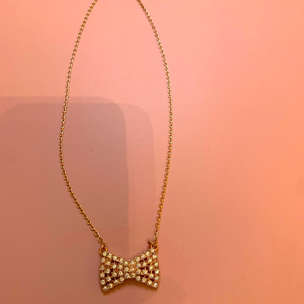 Stylish rose-gold colored Kate Spade classic bow necklace.